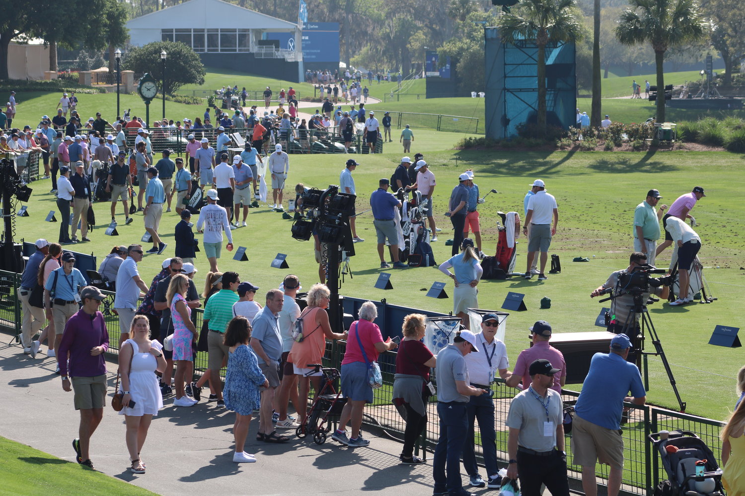 Fans gather around the driving range to get a closer look at the players.